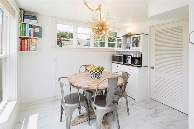 Dining area featuring light marble finish flooring and a chandelier | Image 13