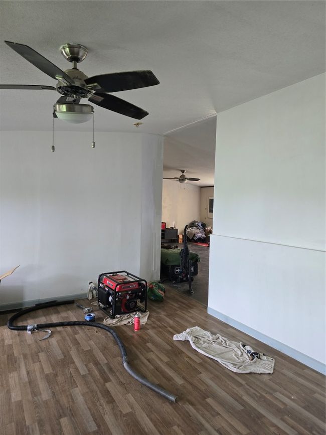 Empty room with ceiling fan, wood finished floors, and baseboards | Image 5