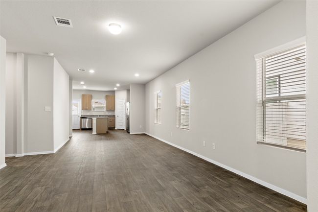 Unfurnished living room with dark wood-style flooring, baseboards, visible vents, and recessed lighting | Image 6