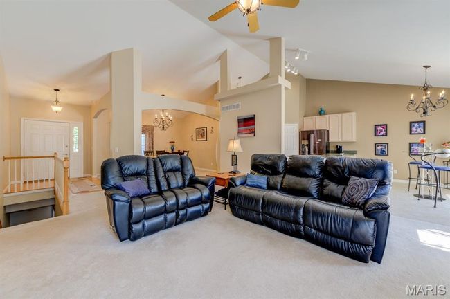 This house has tall ceilings that make use of the high space. The living room leads into the kitchen and dinette area in an open, flowing floor plan. | Image 9