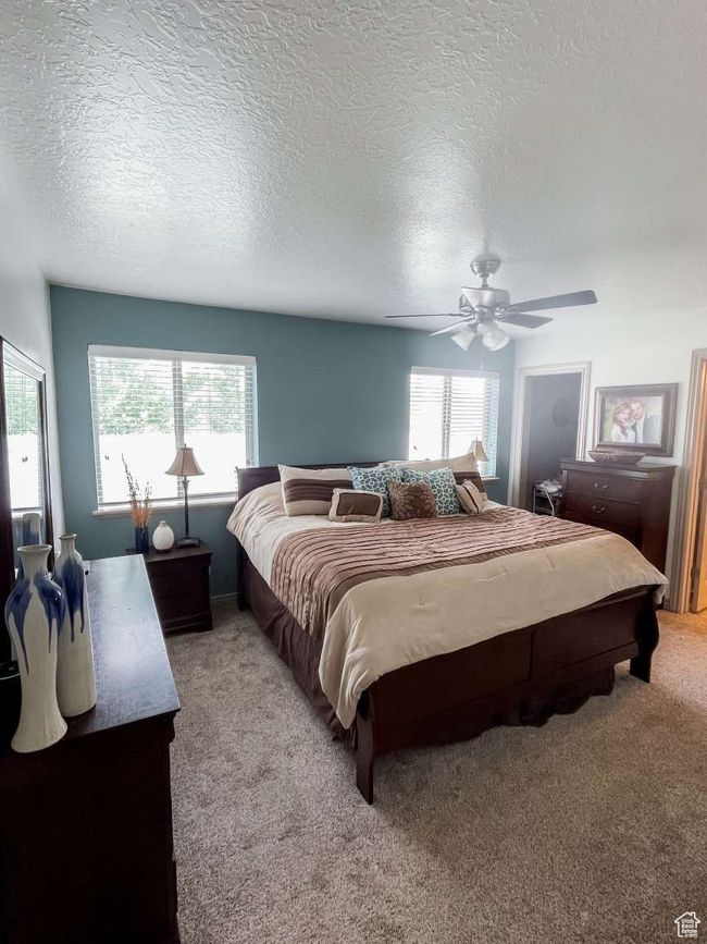 Bedroom with multiple windows, light carpet, a ceiling fan, and a textured ceiling | Image 8