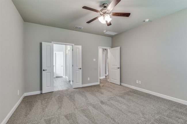 Unfurnished bedroom with ceiling fan and light carpet | Image 19