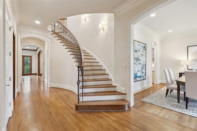 The curved front stairway is set back from the front door, creating a large foyer entrance. The center hall is flanked by the formal living and dining rooms. | Image 3