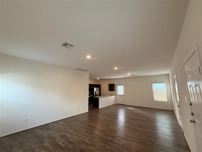 Unfurnished living room with dark wood-type flooring, recessed lighting, baseboards, and a sink | Image 9