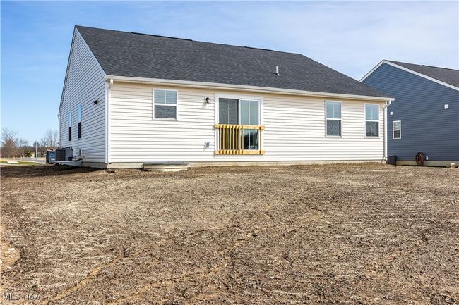 Rear view of house with central AC and a shingled roof | Image 34