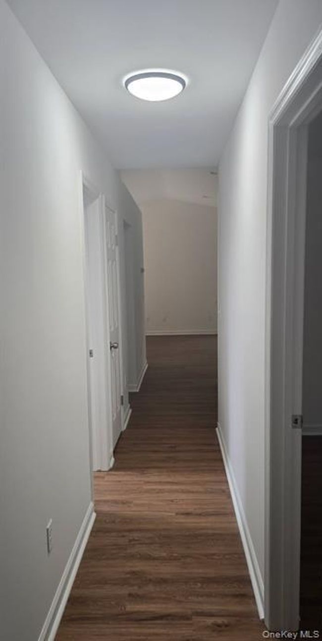 Corridor featuring baseboards and dark wood-style flooring | Image 12