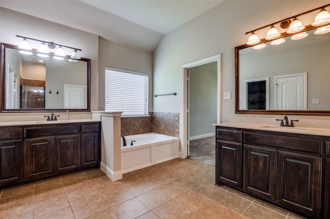 Bathroom with two vanities, a garden tub, tile patterned flooring, and vaulted ceiling | Image 21