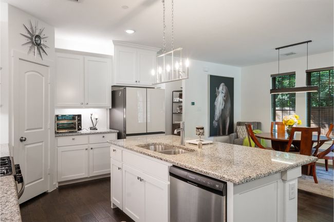 Kitchen with dishwasher, a sink, freestanding refrigerator, dark wood-type flooring, and gas range | Image 7