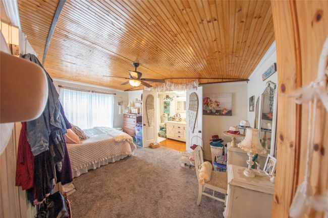 Bedroom with carpet, ceiling fan, and wood ceiling | Image 7