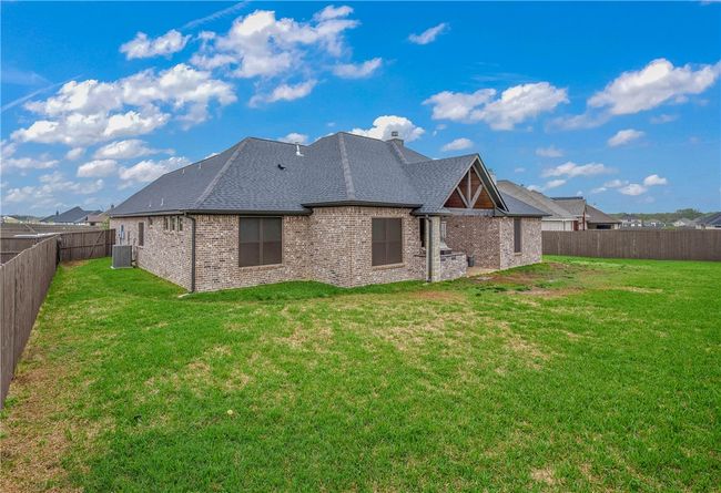 Back of house with central air condition unit, a yard, a fenced backyard, and a chimney | Image 26