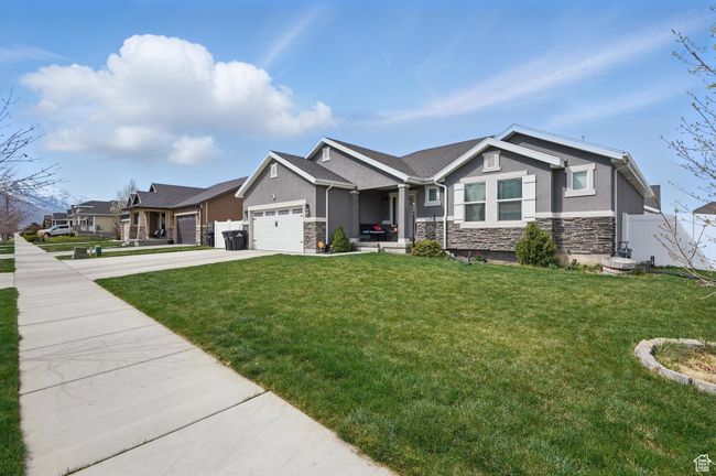Craftsman inspired home with an attached garage, stone siding, fence, stucco siding, and driveway | Image 4