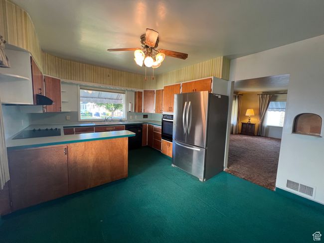 Kitchen with bar seating and area for dining table, stainless steal and black appliances | Image 12