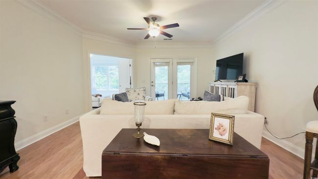 Living room featuring a ceiling fan, ornamental molding, and light wood-style flooring | Image 20