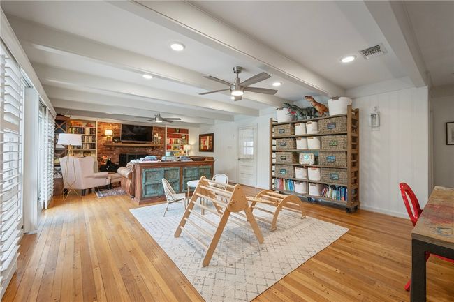 Dining space with light wood-style floors, ceiling fan, a fireplace, beamed ceiling, and baseboards | Image 15