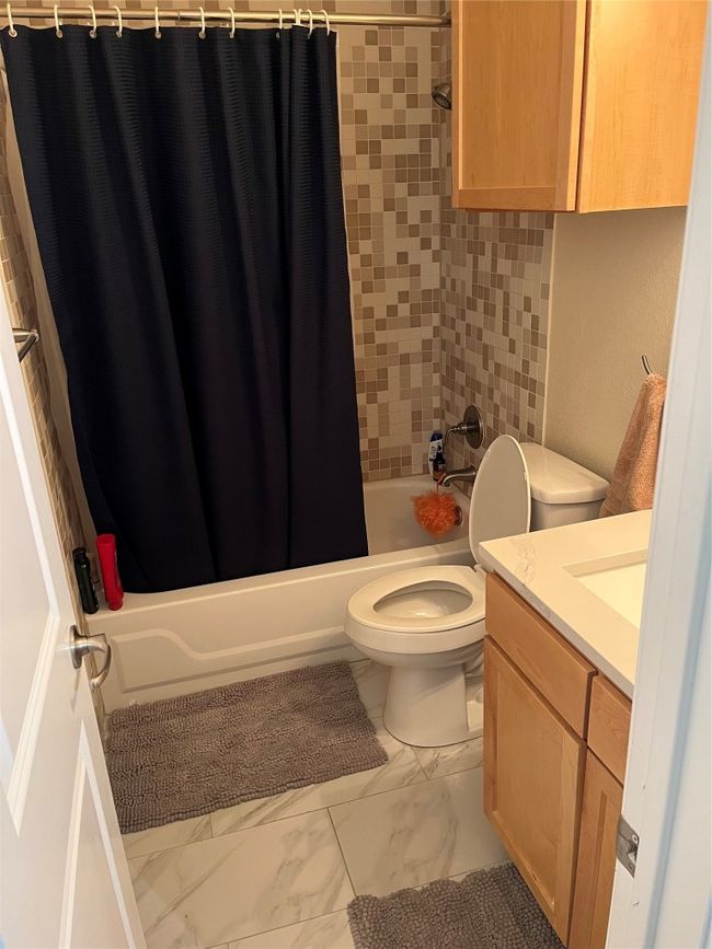 Full bath with marble finish floors, vanity, and shower / tub combo with curtain | Image 11