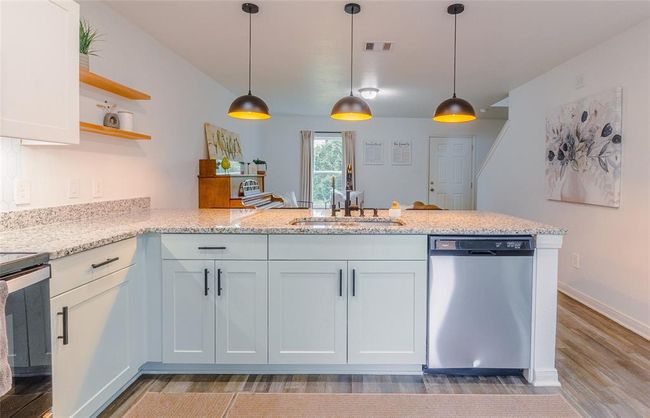 There is a Tankless Reverse Osmosis Filter under the sink. Sellers will be leaving it with filter replacements. The large peninsula gives plenty of room for your family to meal prep together! This kitchen is light and bright with under cabinet lighting, pendants, recessed lighting, and has ample natural light as well. | Image 10