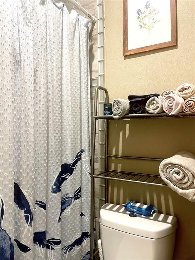 Bathroom with toilet and a shower with curtain | Image 4