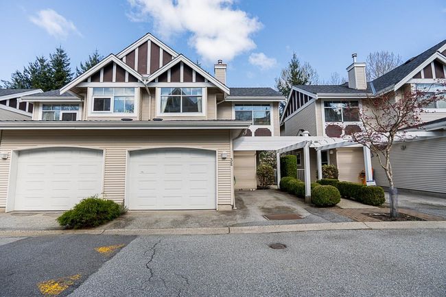 Townhome / multi-family property featuring a garage, driveway, and a chimney | Image 34