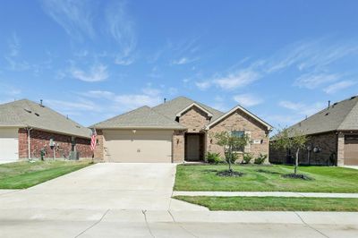 View of front of home featuring central AC, a front yard, and a garage | Image 1