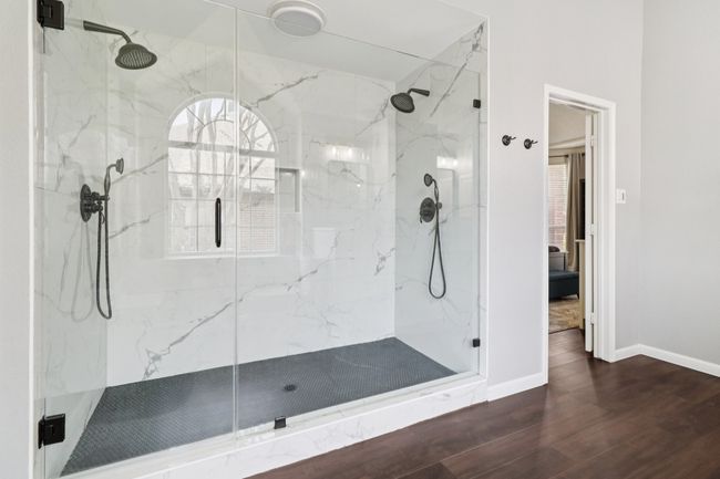 Bathroom with a marble finish shower, wood finished floors, and baseboards | Image 23