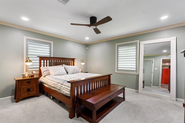The primary suite features good closet space, window shutters, recessed lights and a modern ceiling fan. Per the seller, the wood floors continue under the carpet in this room. | Image 9