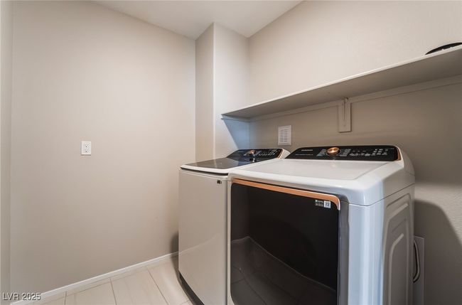 Upstairs Laundry area featuring washer and dryer and light tile patterned floors | Image 38