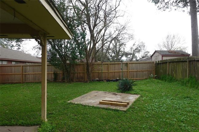 Spacious backyard with lush greenery, perfect for relaxation and outdoor activities. | Image 26