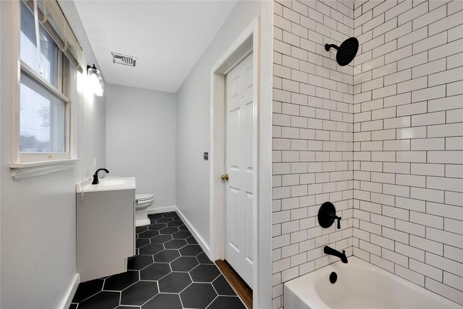Bathroom featuring tile patterned floors, visible vents, toilet, tub / shower combination, and baseboards | Image 15