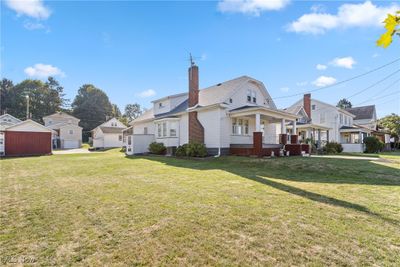 Rear view of property featuring an outbuilding, a lawn, and a porch | Image 3