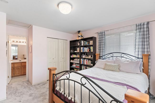 Bedroom featuring light colored carpet, a closet, attic access, connected bathroom, and a sink | Image 27