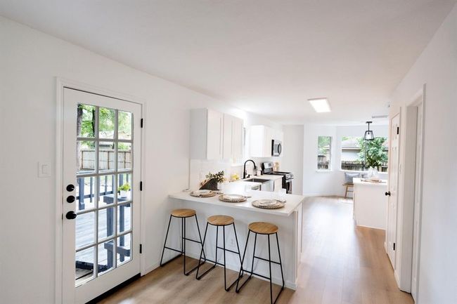 As you walk toward the back, you'll discover a fully remodeled kitchen with an open layout perfect for modern living. | Image 13