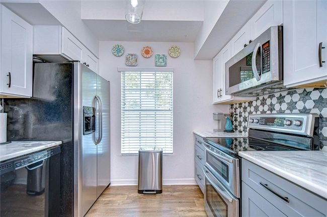 Kitchen has view of the Lake from window. Appliance's include double oven, dishwasher, refrigerator, and microwave. | Image 15
