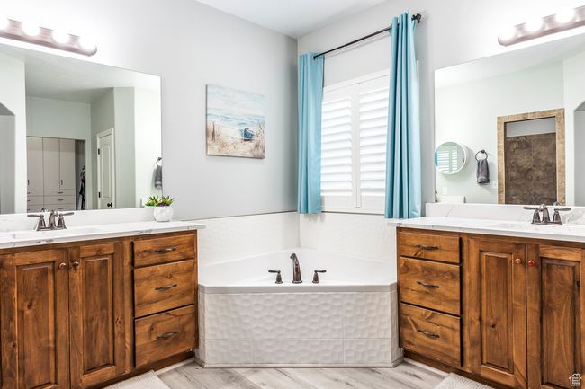 Bathroom with vanity, a bath, and hardwood / wood-style flooring | Image 15