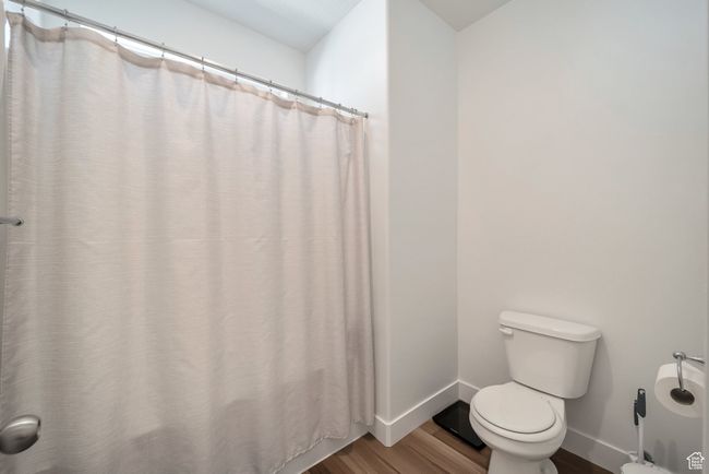 Bathroom featuring wood finished floors, toilet, and baseboards | Image 13