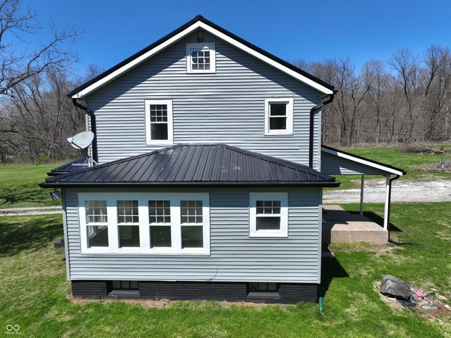 view of side of property with metal roof and a lawn | Image 7