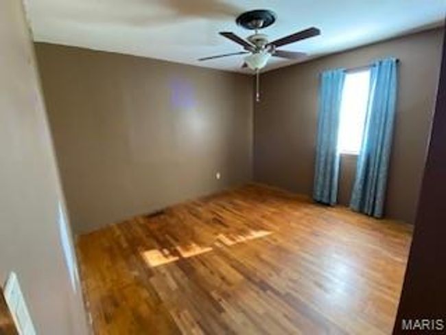 Empty room with wood finished floors and a ceiling fan | Image 7