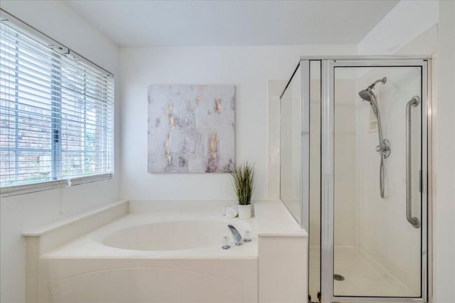 Full bath featuring plenty of natural light, a stall shower, and a bath | Image 19