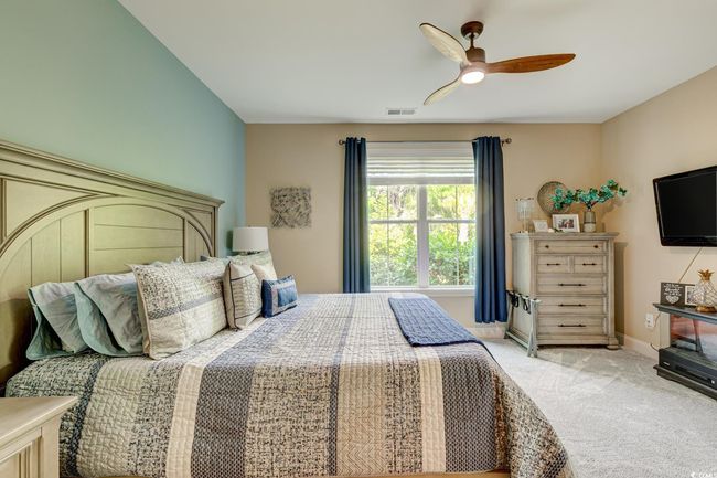 Bedroom with visible vents, carpet flooring, baseboards, and a ceiling fan | Image 19