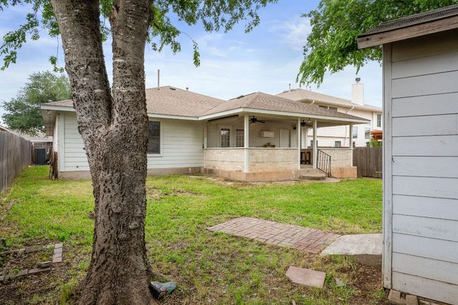 Rear view of property with a yard, cooling unit, a ceiling fan, and a fenced backyard | Image 35
