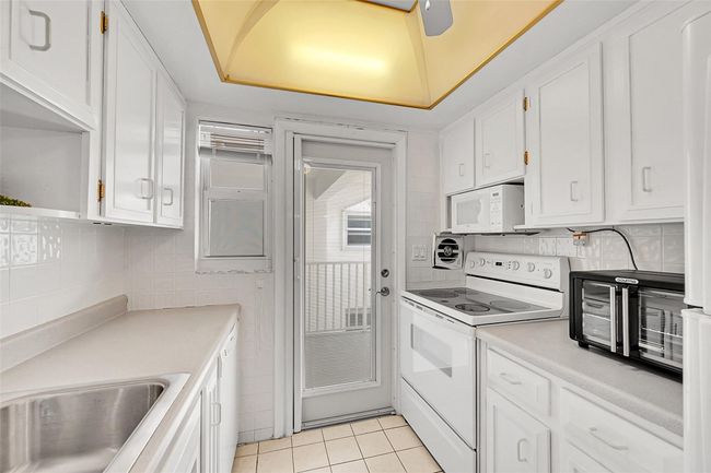 Your Kitchen Features lots of Cupboard and Cabinet Space, is Bright & Has A Door to Your Balcony! Being Sold Furnished, Turn-Key. Impact Windows & Doors also include Blinds and Retractable Screen Doors! | Image 34