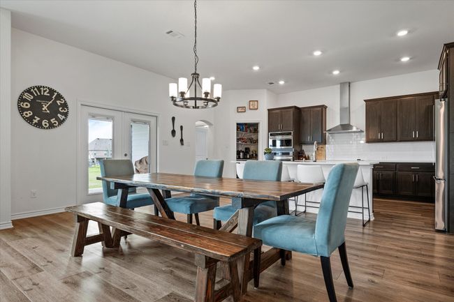 Dining space with arched walkways, wood finished floors, and recessed lighting | Image 10