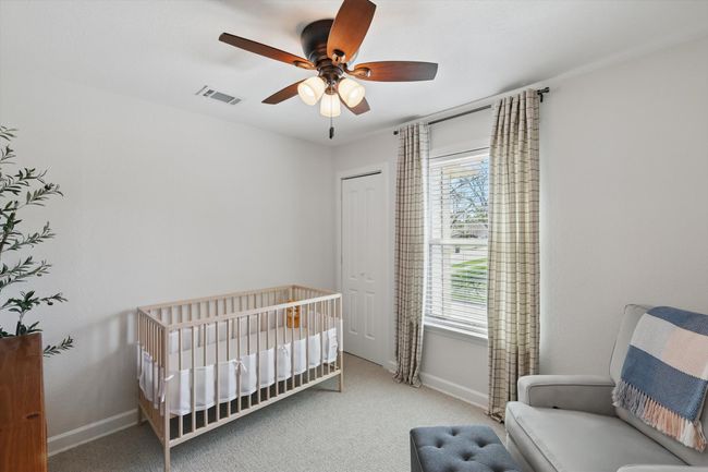 Carpeted bedroom with a crib, a ceiling fan, and a closet | Image 22