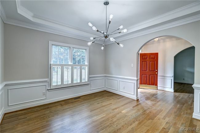 Dining room with wainscoting, crown molding & archway details. | Image 8