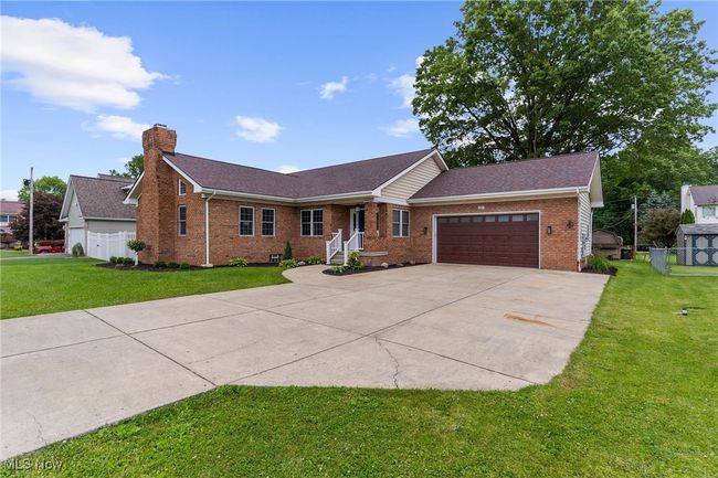 Ranch-style house with brick siding, driveway, an attached garage, a chimney, and roof with shingles | Image 4