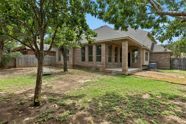 Back of house featuring roof with shingles, brick siding, a patio area, and central AC | Image 33
