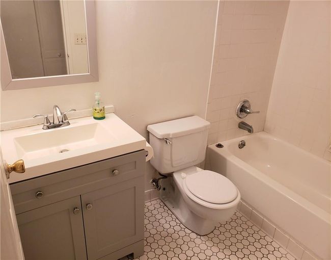 Full bathroom with tile patterned floors, tiled shower / bath combo, vanity, and toilet | Image 11