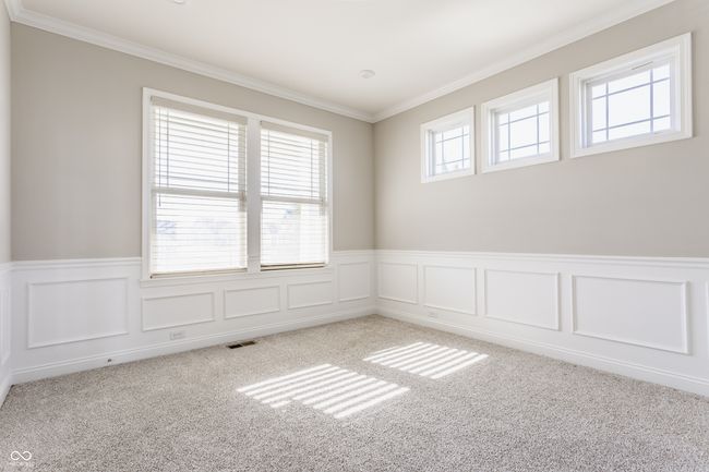 spare room featuring visible vents, light colored carpet, ornamental molding, and wainscoting | Image 11