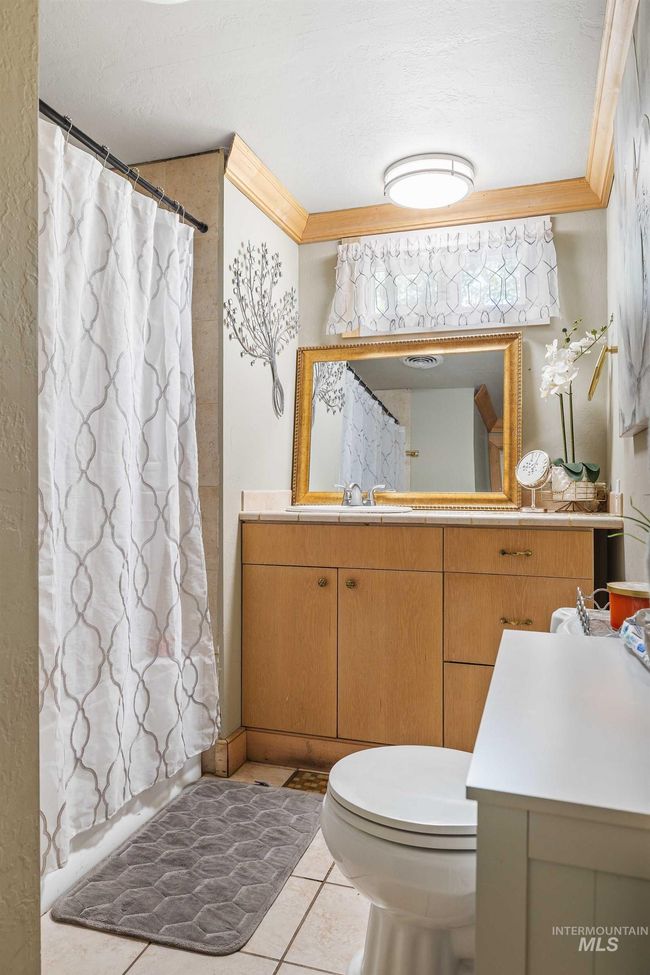 Bathroom with crown molding, vanity, tile patterned floors, curtained shower, and a textured ceiling | Image 13