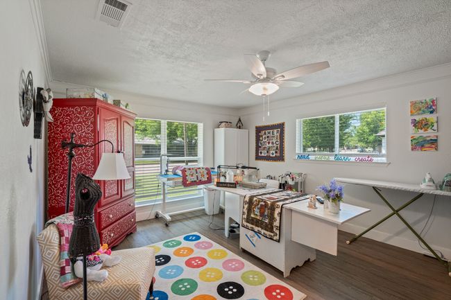 Bedroom with wood finished floors, a textured ceiling, crown molding, and a ceiling fan | Image 28