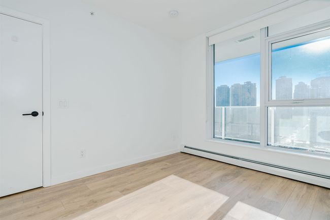 Spare room with visible vents, baseboards, a view of city, wood finished floors, and a baseboard heating unit | Image 20